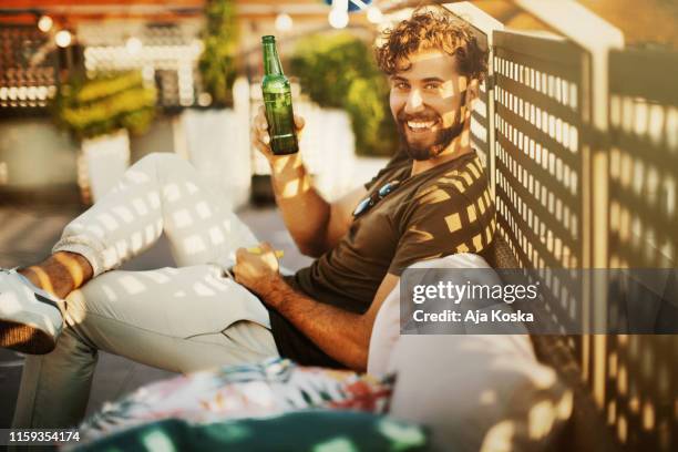 enjoying rooftop party and summer days. - beer bottle cheers stock pictures, royalty-free photos & images