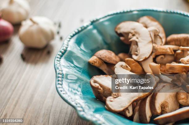 flat lay of freshly chopped shiitake mushroom on a rustic wooden table - cooked mushrooms stock pictures, royalty-free photos & images