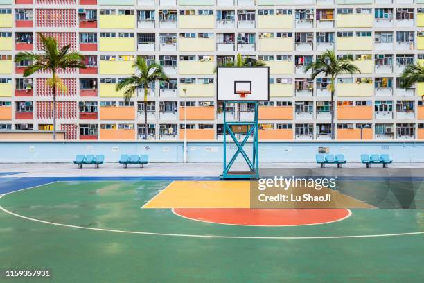 basketball ground with colorful facade of an apartment building in hong kong - district court stock pictures, royalty-free photos & images