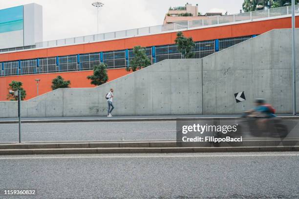 young adult businessman in the middle of the city traffic - blurred cars - milan street fashion 2019 imagens e fotografias de stock