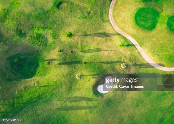 a golf course with trees and shadows from above - bermuda stock pictures, royalty-free photos & images