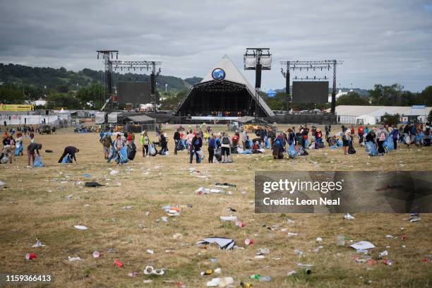 Clean-up crews clear litter and debris from the area in front of thePyramid Stage on the morning after the final night of the Glastonbury Festival at...
