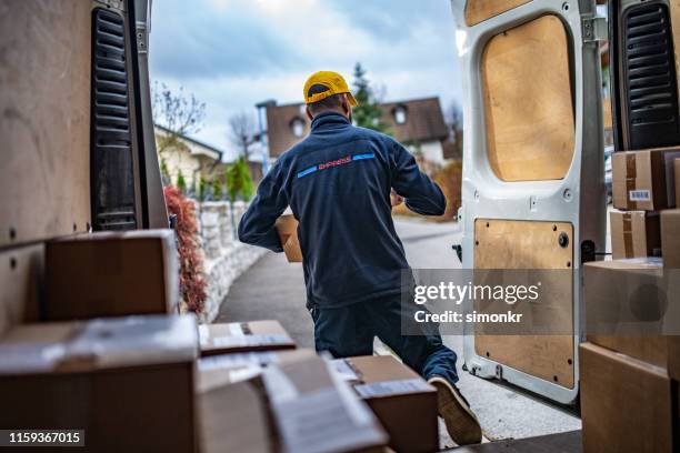 delivery man lopen van van - zwart jak stockfoto's en -beelden