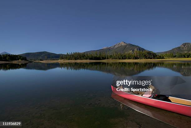 schöne frau entspannenden in kanu auf der mountain lake - punting stock-fotos und bilder