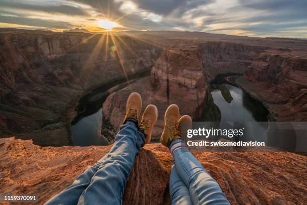 prospettiva personale di coppia rilassante in cima al grand canyon; vista piedi; le persone viaggiano vacanze concetto di relax - soggettiva foto e immagini stock