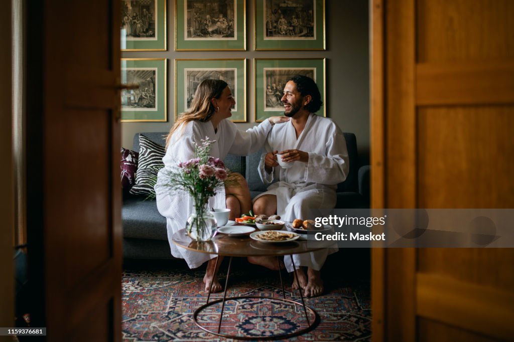 Happy couple in bathrobes in hotel room