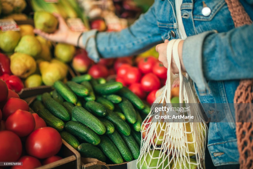 Vegetables and fruit in reusable bag on a farmers market, zero waste concept
