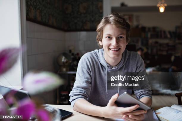 portrait of smiling teenage boy studying at home - boy computer smile fotografías e imágenes de stock