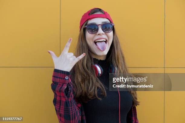 hipster coole mädchen in sonnenbrille - sticking out tongue stock-fotos und bilder