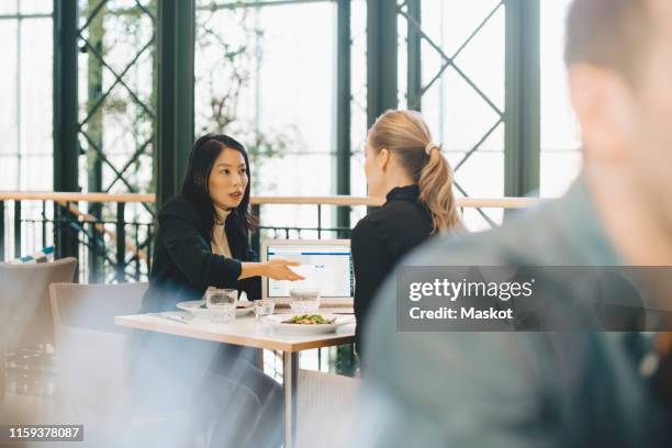 confident businesswomen planning strategy at table during meeting in cafeteria - workplace canteen lunch stock pictures, royalty-free photos & images