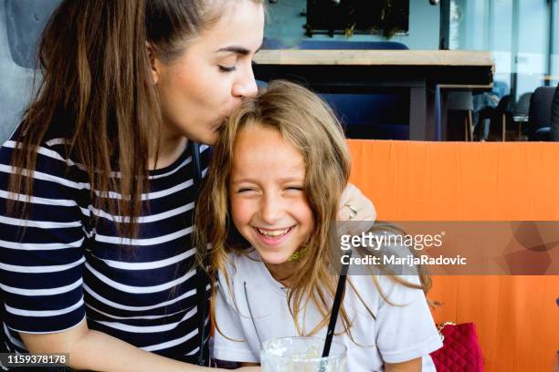supportive sister. loving supportive younger sister smiling while hugging her little beautiful girl - older sister stock pictures, royalty-free photos & images