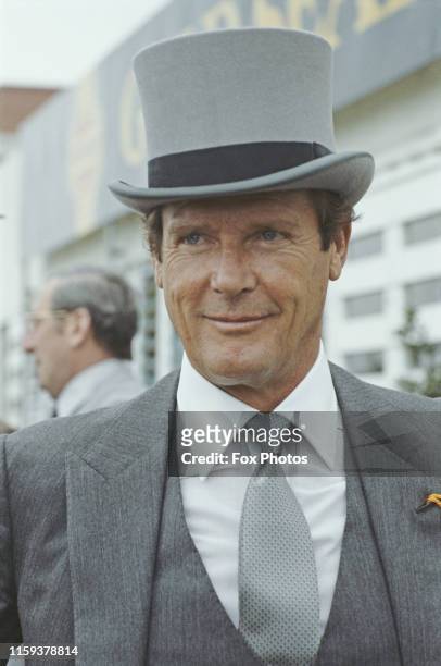 English actor Roger Moore wearing a top hat at the Epsom Derby, England, 5th June 1985.