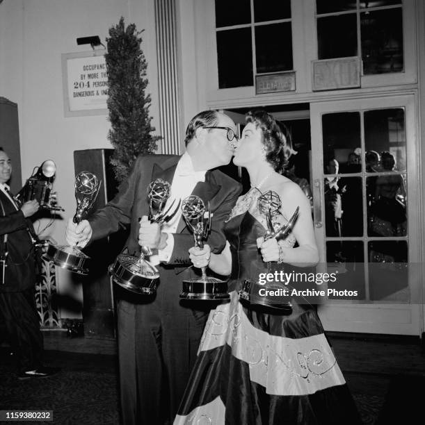 American actor and comedian Phil Silvers , winner of the award for Best Actor in a Continuing Performance, kisses actress, singer and dancer Nanette...