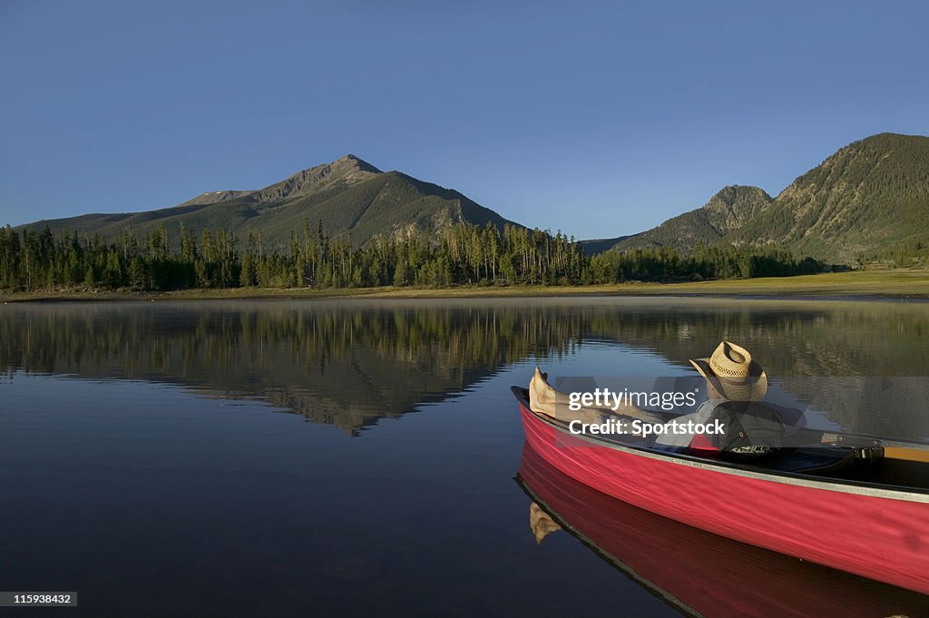 Man Relaxing in Canoe with Mountain View