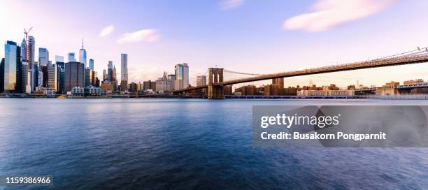 new york city skyline with brooklyn bridge and lower manhattan view at sunset - bridge stock photos et images de collection