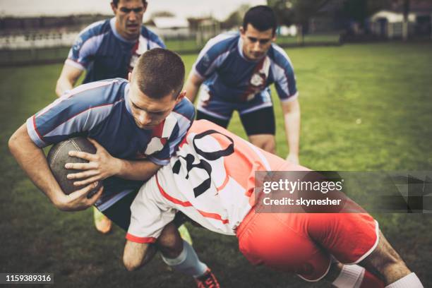 het blokkeren van de tegenstander op een rugby wedstrijd! - rugby tackle stockfoto's en -beelden