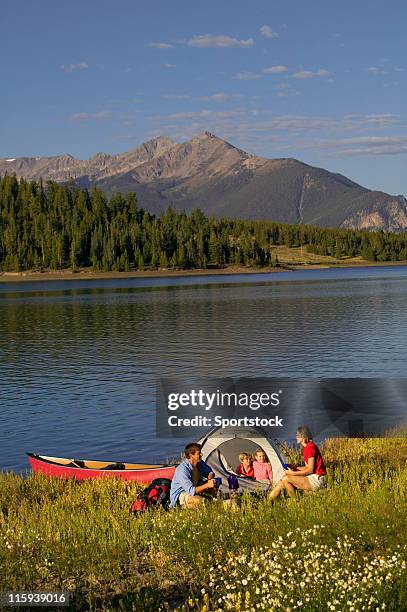 family camping on mountain lake with canoe - family red canoe stock pictures, royalty-free photos & images