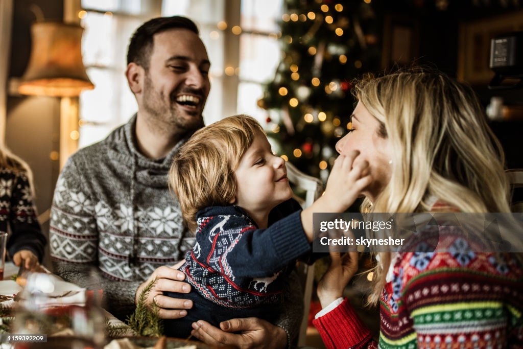 Young affectionate family enjoying during New Year's day in dining room.