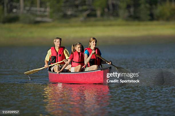 family canoeing on mountain lake - family red canoe stock pictures, royalty-free photos & images