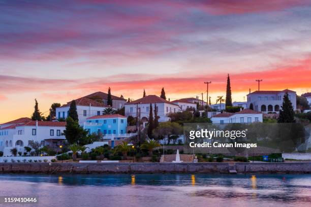 evening view of spetses village from the harbour pier, greece. - spetses stock pictures, royalty-free photos & images