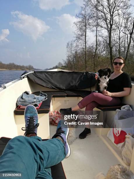 lazy weekend boat ride with a young woman and her dogs. - hairy legs stock pictures, royalty-free photos & images