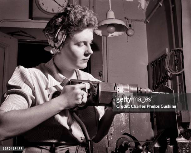 1940s PATRIOTIC ANONYMOUS UNIDENTIFIED WOMAN HOME FRONT INDUSTRIAL WORKER USING ELECTRICAL HAND DRILL DURING WORLD WAR II