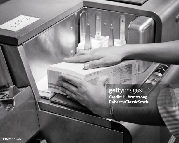 1960s WOMAN'S HANDS LOADING DATA PUNCHED CARDS INTO 20TH CENTURY COMPUTER CARD READER MACHINE