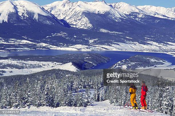 couple on ski slopes by mountain lake - womens us ski team stock pictures, royalty-free photos & images