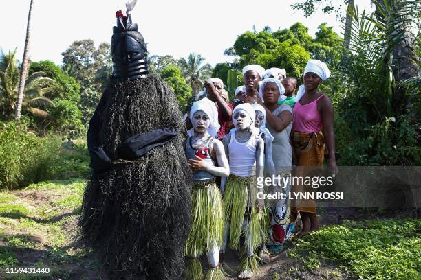 Secret Bondo society members are led by the Black Devil as they begin their procession across the field of Songo village in order to perform on...