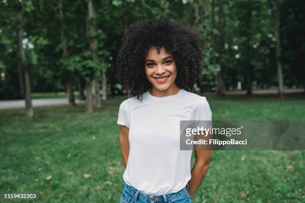 portrait of a mixed race young woman outdoor - t shirt stock pictures, royalty-free photos & images