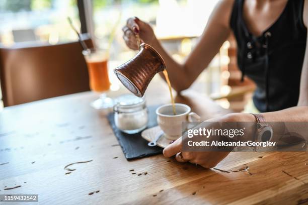 traditionele turkse koffie gegoten in de beker - cezve stockfoto's en -beelden