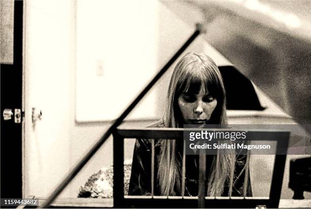 Joni Mitchell playing a piano in the recording booth, during a session for her first album, 'Song To A Seagull', at Sunset Sound Recorders,...