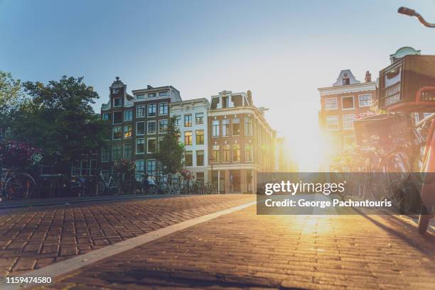 sunset on a street in amsterdam - hollands landschap stockfoto's en -beelden