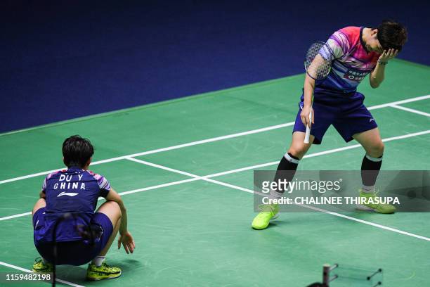 China's Li Yin Hui and Du Yue react against Japan's Shiho Tanaka and Koharu Yonemoto during their women's doubles final match at the Thailand Open...