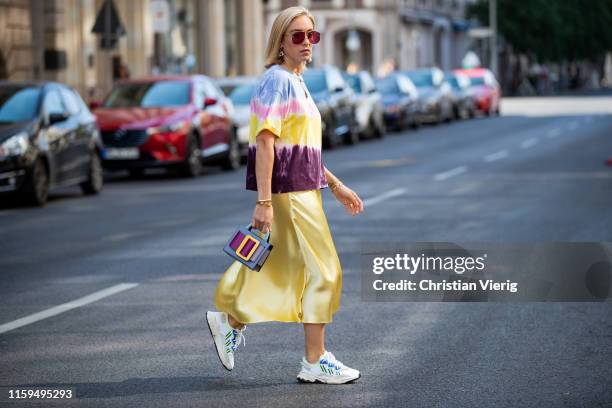 Sonia Lyson is seen wearing sneaker Adidas, yellow satin skirt Zara, batik shirt Zara, Boyy bag, Wald Berlin jewellery, Dior sunglasses during...