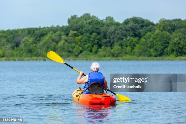 senior woman kayaking on lake in summer - life jacket stock pictures, royalty-free photos & images
