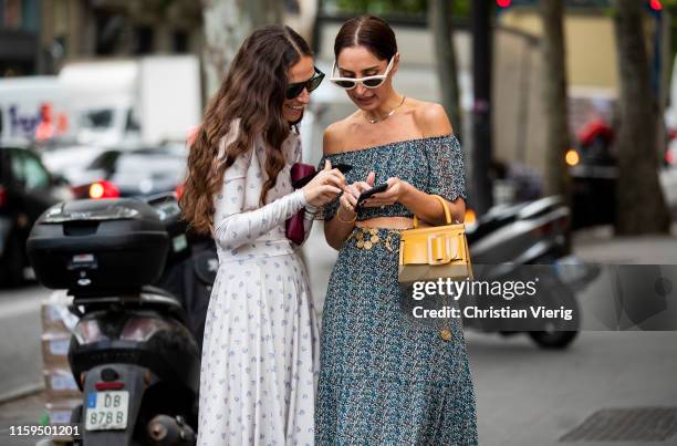 Géraldine Boublil is seen wearing grey off shoulder dress, yellow bag, Erika Boldrin on their smartphone outside Schiaparelli during Paris Fashion...