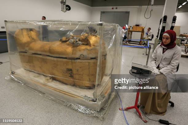 August 2019, Egypt, Giza: An Egyptian archaeologist works on the gilded coffin of King Tutankhamun during a restoration process, the first since the...