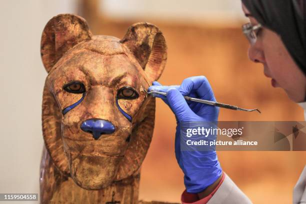 August 2019, Egypt, Giza: An Egyptian archaeologist works on a pharaonic bed with animal figures which belonged to King Tutankhamun during a...