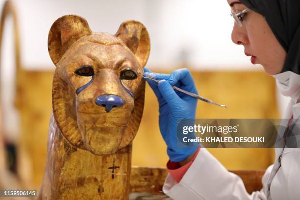 An Egyptian archaeologist restores the throne of the throne of King Tutankhamun at the conservation center in the Grand Egyptian Museum on August 4,...