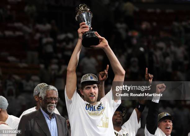 Dirk Nowitzki of the Dallas Mavericks holds up the Bill Russell Finals MVP trophy after Bill Russell presented it to him following the Mavericks...