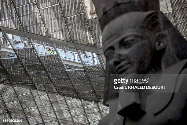 This picture taken on August 4, 2019 shows the 3,200-year-old pink-granite colossal statue of King Ramses II at the entrance of the Grand Egyptian...
