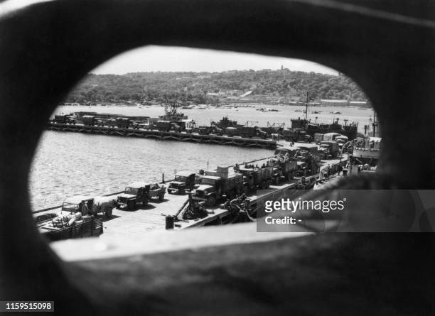 Reproduction d'une photographie réalisée en 1943 montrant des véhicules et du matériel militaire américain débarquant au port de Porto-Vecchio....