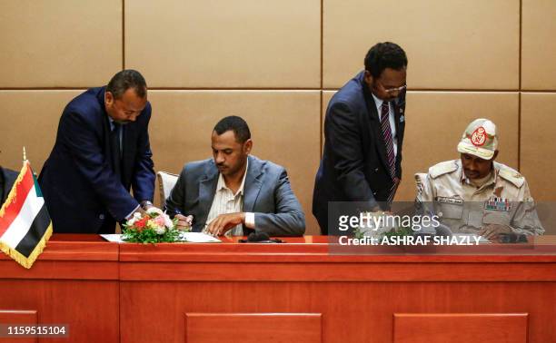 General Mohamed Hamdan Daglo , Sudan's deputy head of the Transitional Military Council, and protest leader Ahmed Rabie sign the constitutional...