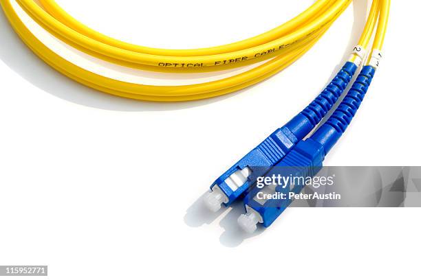 optical fiber cable - yellow with blue connectors - computer cable stock pictures, royalty-free photos & images