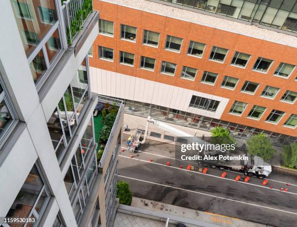 high-altitude work using the lifting platform in harlem, new york city. high-angle view. - roof replacement stock pictures, royalty-free photos & images