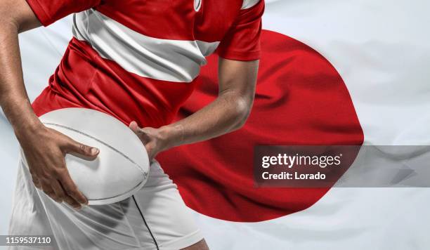 rugby-spieler mit ball und japanischer flagge - rugby japan stock-fotos und bilder