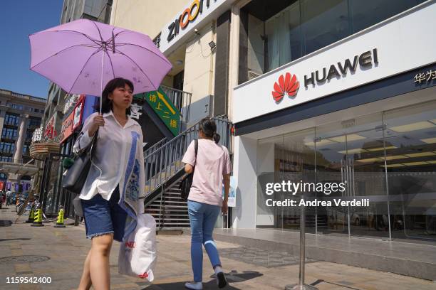 People walk past a Huawei store on July 1, 2019 in Dongdaqiao, Chaoyang District, Beijing.