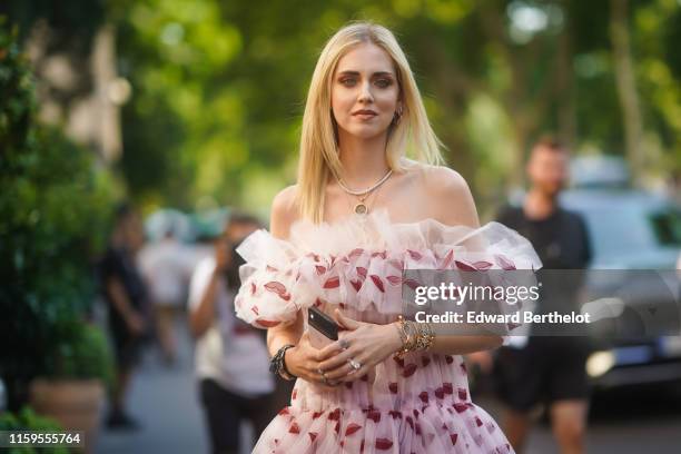 Chiara Ferragni wears an off-shoulder ruffled lace dress with printed red lips, outside Giambattista Valli, during Paris Fashion Week -Haute Couture...