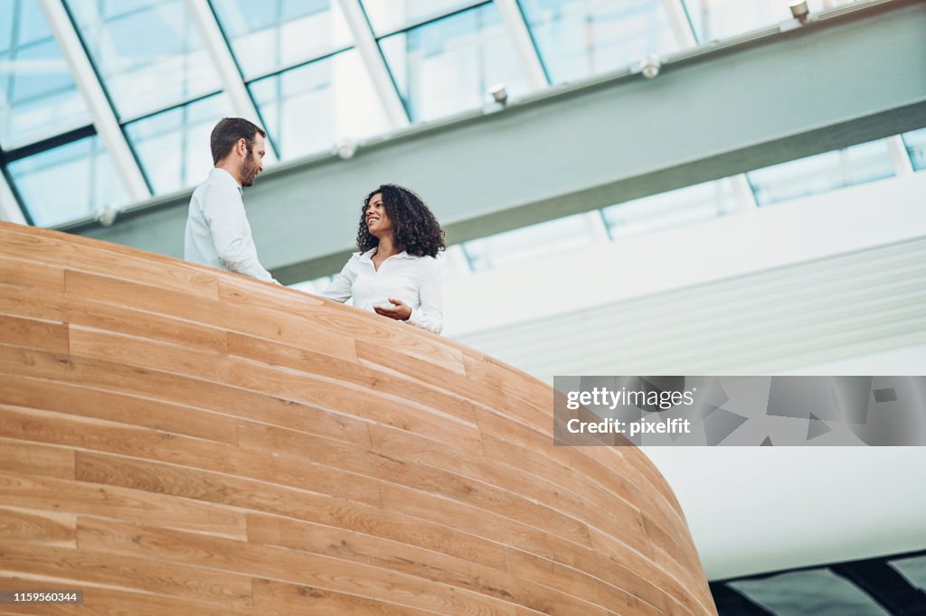 Couple of business persons talking in modern office space